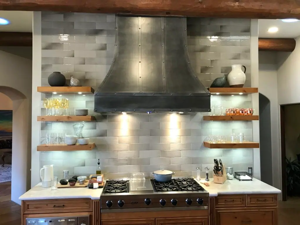 Range with zinc-style hood, tile backsplash and floating shelves
